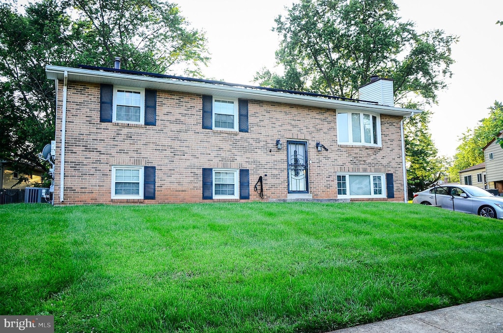 5702 Justina Dr, Lanham, MD 20706 - split foyer home with a chimney, brick siding, and a front yard