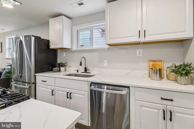 919 Mentor Ave, Capitol Heights, MD 20743 - kitchen featuring stainless steel appliances, white cabinets, and light stone countertops