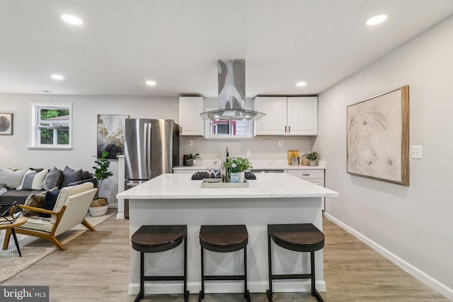 919 Mentor Ave, Capitol Heights, MD 20743 - kitchen with island exhaust hood, a kitchen breakfast bar, white cabinetry, recessed lighting, and light stone countertops
