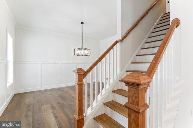 171 Ellicott Rd, Avondale, PA 19311 - stairs with wood finished floors, a chandelier, crown molding, wainscoting, and a decorative wall