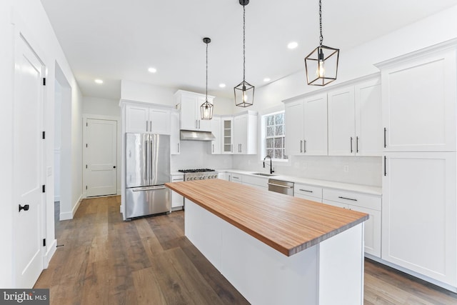171 Ellicott Rd, Avondale, PA 19311 - kitchen featuring appliances with stainless steel finishes, under cabinet range hood, butcher block countertops, a center island, and white cabinetry