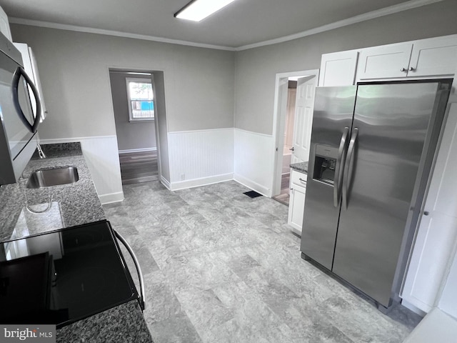 122 W N St, Waynesboro, PA 17268 - kitchen with appliances with stainless steel finishes, ornamental molding, white cabinetry, dark stone countertops, and wainscoting