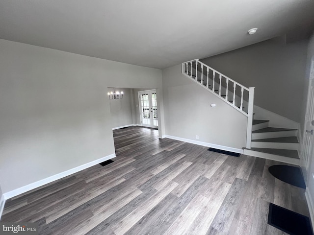 122 W N St, Waynesboro, PA 17268 - unfurnished living room with stairway, dark wood finished floors, a chandelier, and french doors