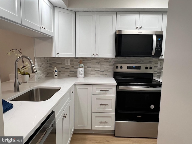 9220 Redbridge Ct, Laurel, MD 20723 - kitchen with stainless steel appliances, white cabinets, tasteful backsplash, light wood-style floors, and light stone countertops