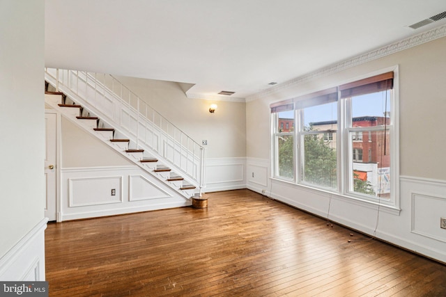 1803 T St NW Unit 11, Washington, DC 20009 - unfurnished living room with stairs, wainscoting, hardwood / wood-style floors, a decorative wall, and ornamental molding