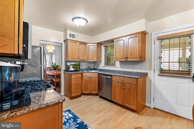 5139 Celestial Way, Columbia, MD 21044 - kitchen featuring stainless steel appliances, light wood finished floors, brown cabinetry, and dark stone counters