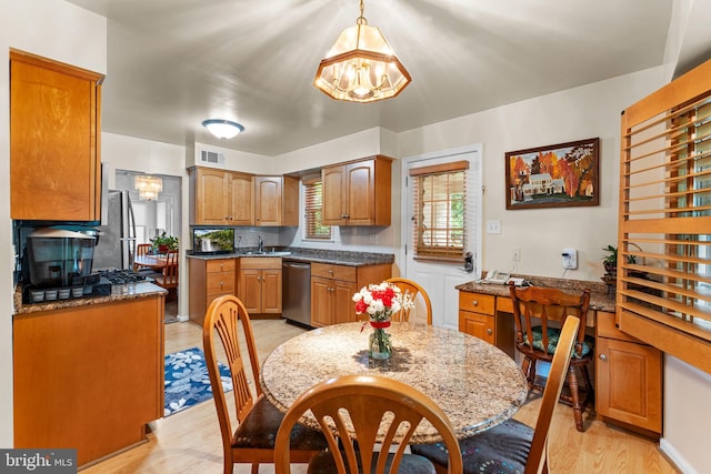 5139 Celestial Way, Columbia, MD 21044 - kitchen with appliances with stainless steel finishes, a chandelier, light wood-style flooring, brown cabinetry, and pendant lighting