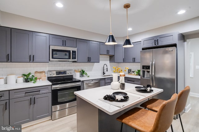 3910 E Pratt St, Baltimore, MD 21224 - kitchen featuring stainless steel appliances, a kitchen bar, light wood-style floors, backsplash, and recessed lighting