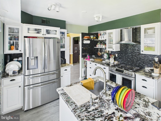 2101 Waterleaf Way, Bowie, MD 20721 - kitchen with appliances with stainless steel finishes, wall chimney range hood, backsplash, white cabinetry, and light wood-style flooring