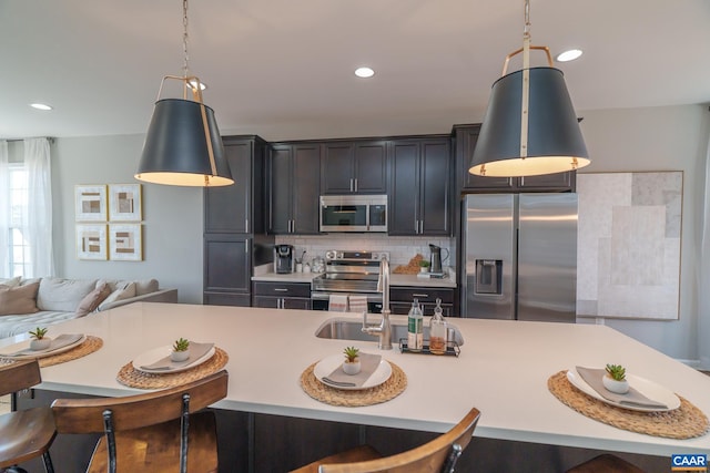 421 Willowshire Ct, Waynesboro, VA 22980 - kitchen featuring stainless steel appliances, a breakfast bar area, light countertops, backsplash, and decorative light fixtures
