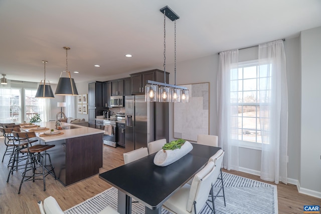 421 Willowshire Ct, Waynesboro, VA 22980 - kitchen with appliances with stainless steel finishes, an island with sink, a kitchen breakfast bar, light countertops, and light wood finished floors
