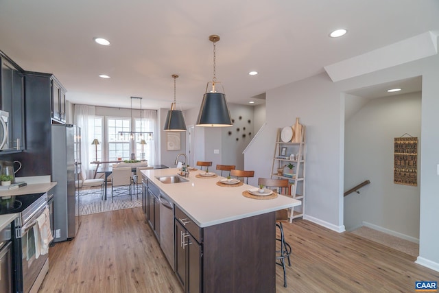 421 Willowshire Ct, Waynesboro, VA 22980 - kitchen with stainless steel appliances, a breakfast bar, an island with sink, light countertops, and light wood-style flooring