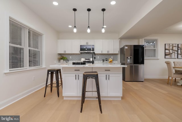 1117 Overbrook Rd, Baltimore, MD 21239 - kitchen with stainless steel refrigerator with ice dispenser, light wood-style flooring, a kitchen breakfast bar, light countertops, and recessed lighting