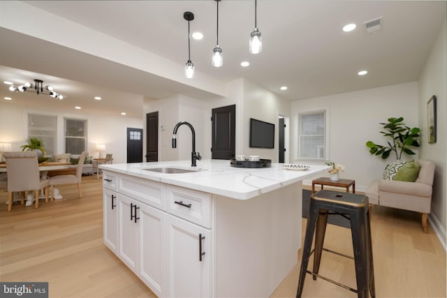 1117 Overbrook Rd, Baltimore, MD 21239 - kitchen featuring open floor plan, light wood-style floors, light stone countertops, recessed lighting, and white cabinets