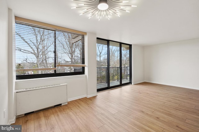 600 Roosevelt Blvd Unit 316, Falls Church, VA 22044 - empty room with radiator, wood finished floors, and a chandelier