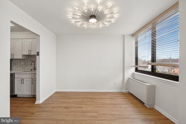 600 Roosevelt Blvd Unit 316, Falls Church, VA 22044 - unfurnished dining area featuring a chandelier, radiator heating unit, and light wood finished floors