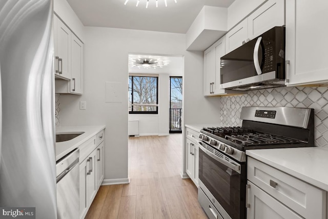600 Roosevelt Blvd Unit 316, Falls Church, VA 22044 - kitchen with stainless steel appliances, backsplash, light countertops, and light wood-style flooring