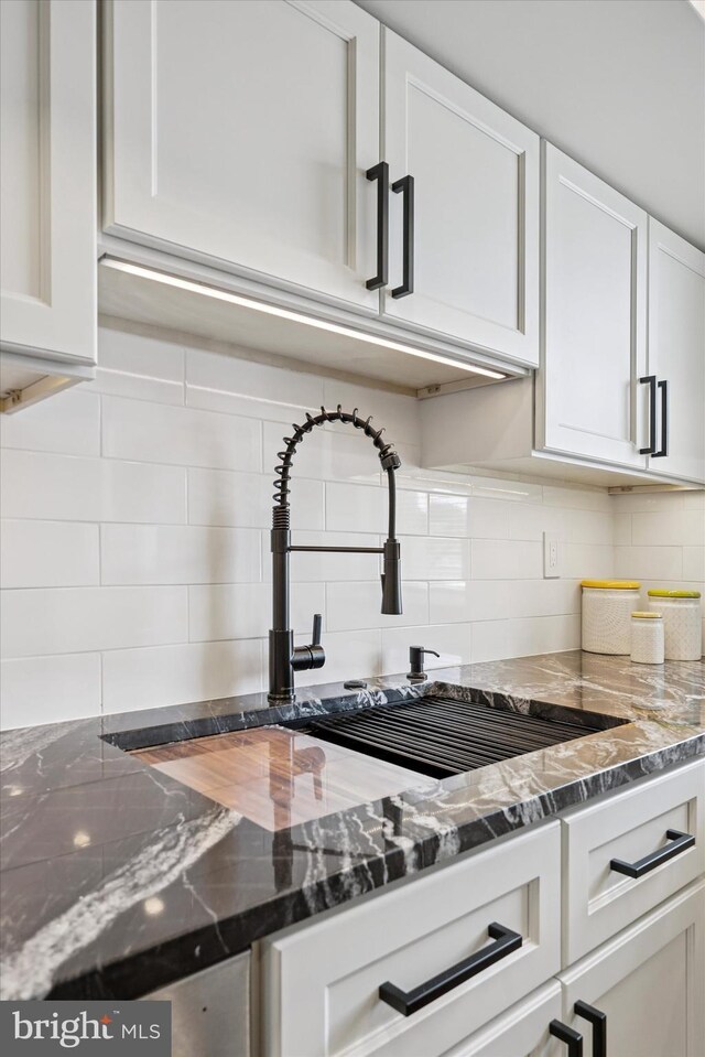 181 Levering St, Philadelphia, PA 19127 - kitchen with white cabinets, decorative backsplash, and dark stone countertops