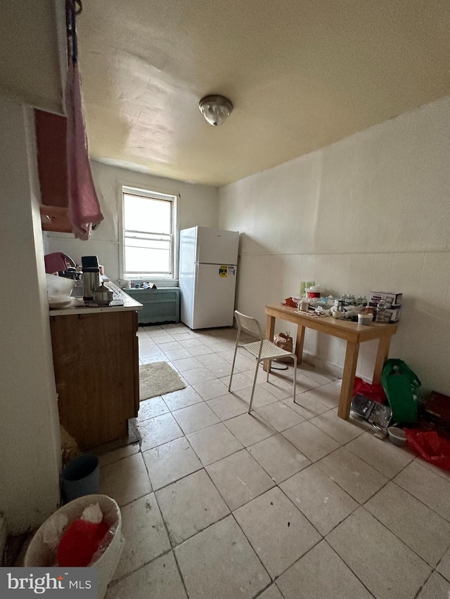 1825 S 8th St, Philadelphia, PA 19148 - kitchen featuring freestanding refrigerator, light tile patterned floors, wainscoting, and a textured ceiling