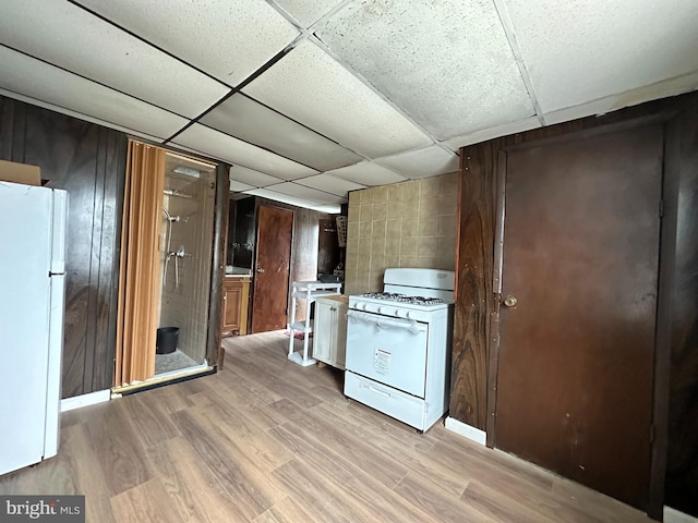 1825 S 8th St, Philadelphia, PA 19148 - kitchen with white appliances, light wood finished floors, dark brown cabinetry, and a paneled ceiling
