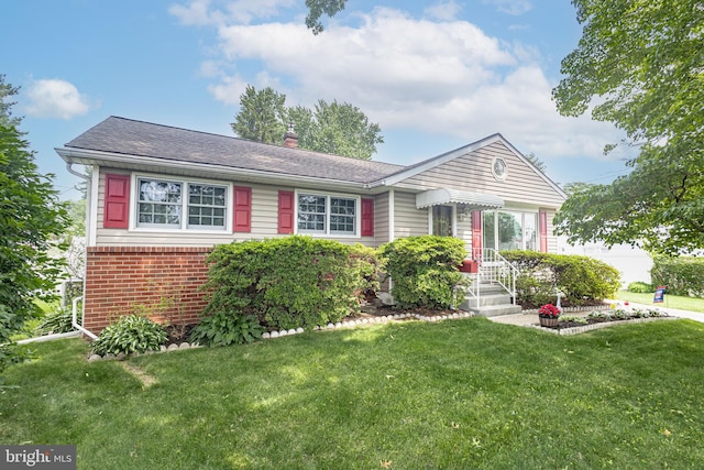 3735 Donegal Ln, Brookhaven, PA 19015 - view of front of house featuring a front yard, a chimney, brick siding, and roof with shingles