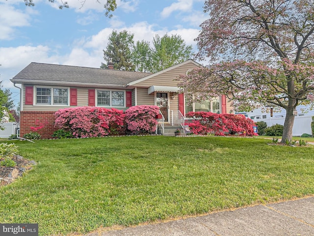 3735 Donegal Ln, Brookhaven, PA 19015 - view of front of house with a front yard, a chimney, brick siding, and a shingled roof