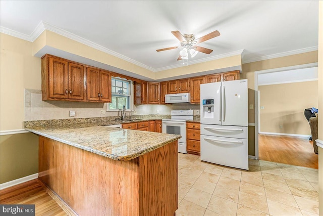 228 Benjamin Blvd, Bear, DE 19701 - kitchen with white appliances, a peninsula, brown cabinetry, a ceiling fan, and light stone countertops