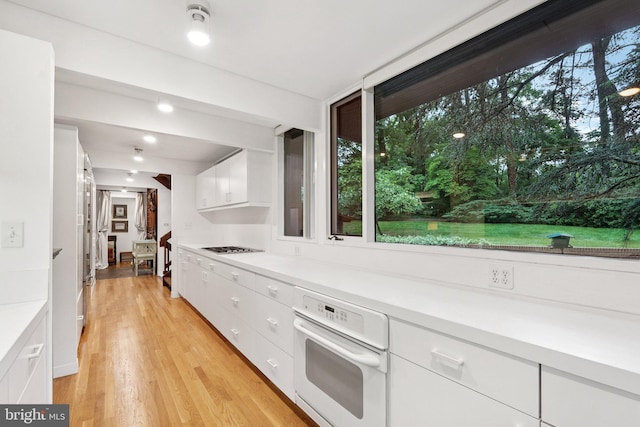 1330 Potomac School Rd, Mclean, VA 22101 - kitchen featuring white oven, white cabinets, light countertops, and light wood finished floors