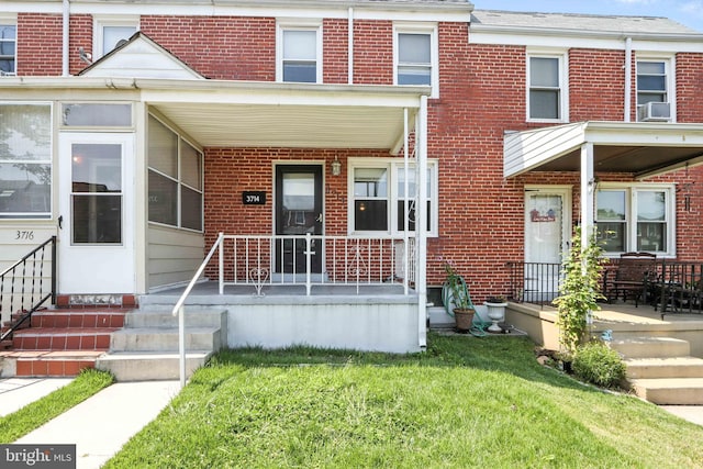 3714 Greenvale Rd, Baltimore, MD 21229 - view of front of property with a porch, brick siding, cooling unit, and a front lawn