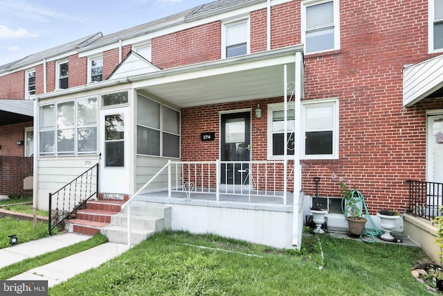 3714 Greenvale Rd, Baltimore, MD 21229 - view of front of home with brick siding, covered porch, and a front yard