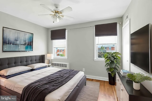 3714 Greenvale Rd, Baltimore, MD 21229 - bedroom featuring radiator, multiple windows, wood finished floors, and a ceiling fan