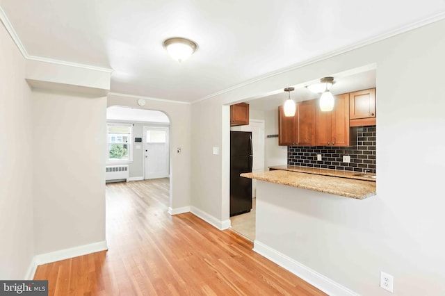 3714 Greenvale Rd, Baltimore, MD 21229 - kitchen featuring freestanding refrigerator, radiator heating unit, tasteful backsplash, arched walkways, and light wood-style flooring