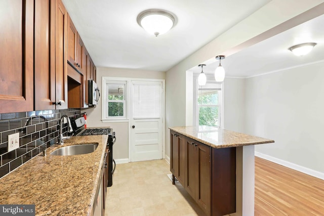 3714 Greenvale Rd, Baltimore, MD 21229 - kitchen featuring appliances with stainless steel finishes, backsplash, light stone countertops, brown cabinets, and pendant lighting