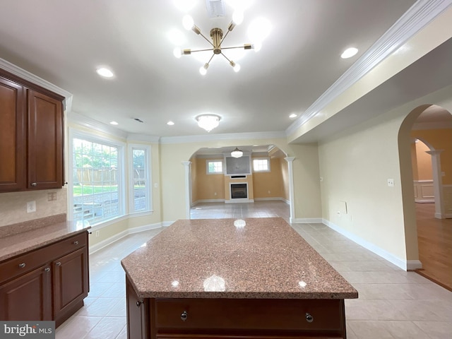 7212 Highland St, Springfield, VA 22150 - kitchen featuring arched walkways, ornamental molding, light stone counters, a chandelier, and a kitchen island