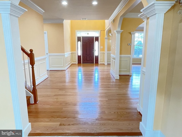 7212 Highland St, Springfield, VA 22150 - entryway featuring ornate columns, crown molding, a decorative wall, light wood finished floors, and a wainscoted wall