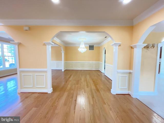 7212 Highland St, Springfield, VA 22150 - unfurnished dining area with decorative columns, arched walkways, ornamental molding, wood finished floors, and a decorative wall