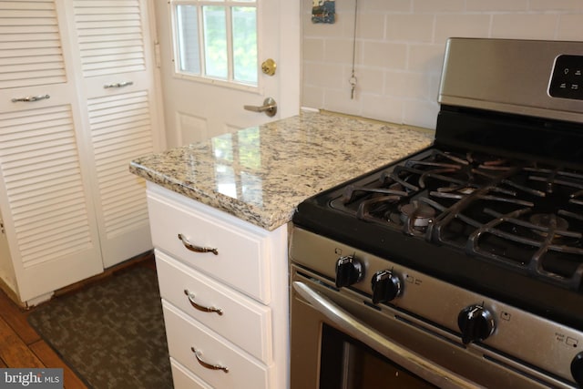 814 Morgan Ave, Palmyra, NJ 08065 - kitchen with stainless steel gas range oven, tasteful backsplash, light stone countertops, white cabinetry, and dark wood-style flooring
