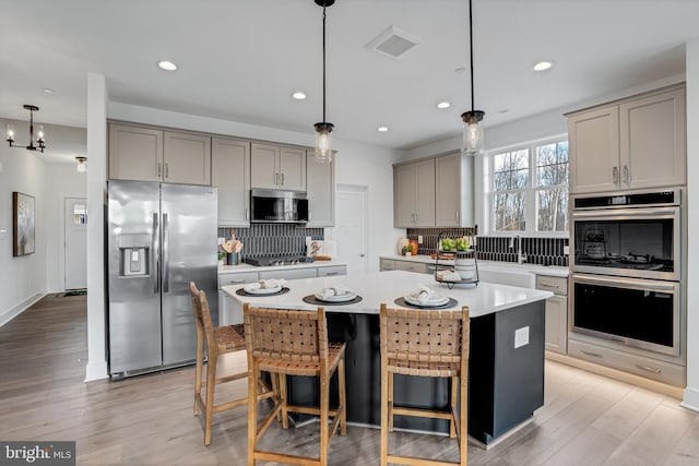 539 Whimsical Dr, Havre De Grace, MD 21078 - kitchen featuring stainless steel appliances, gray cabinetry, light countertops, decorative backsplash, and recessed lighting