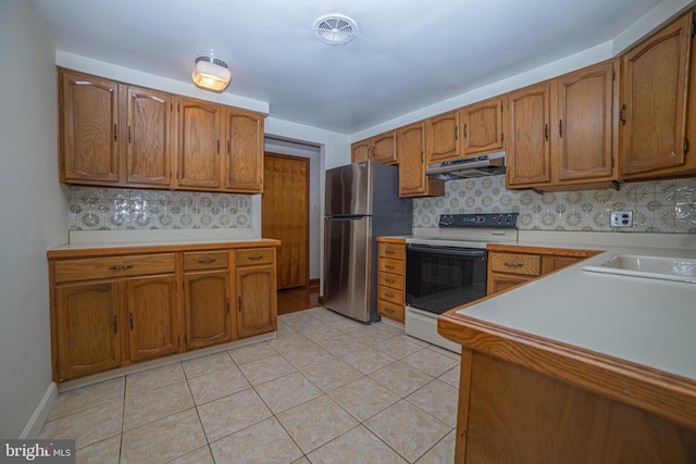 4117 Chichester Ave, Upper Chichester, PA 19061 - kitchen featuring white electric range, under cabinet range hood, freestanding refrigerator, and brown cabinetry