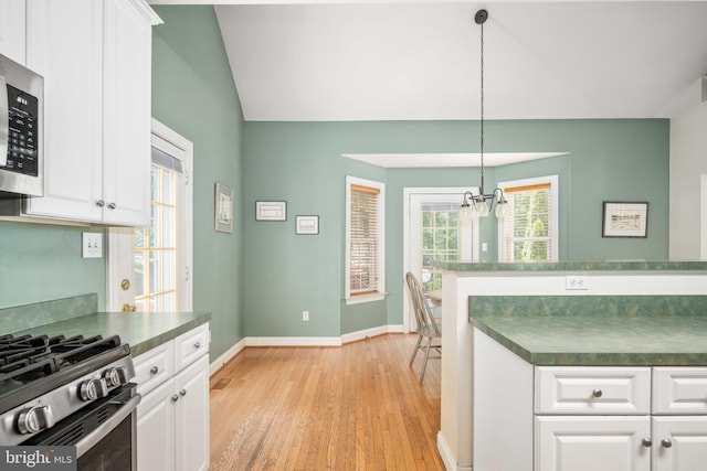 4 Monument Dr, Stafford, VA 22554 - kitchen featuring dark countertops, vaulted ceiling, stainless steel microwave, a chandelier, and light wood-type flooring