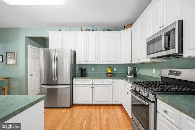 4 Monument Dr, Stafford, VA 22554 - kitchen with appliances with stainless steel finishes, dark countertops, white cabinetry, and light wood finished floors
