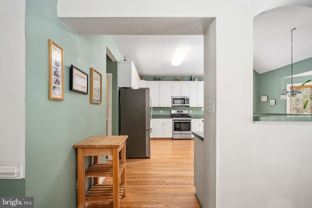 4 Monument Dr, Stafford, VA 22554 - kitchen featuring appliances with stainless steel finishes, white cabinetry, light wood-type flooring, a chandelier, and arched walkways
