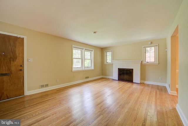 6717 44th Ave, Hyattsville, MD 20782 - unfurnished living room featuring light wood-type flooring and a brick fireplace