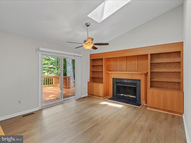 900 Young Dairy Ct, Herndon, VA 20170 - unfurnished living room with built in features, a skylight, lofted ceiling, a fireplace with raised hearth, and light wood-style floors