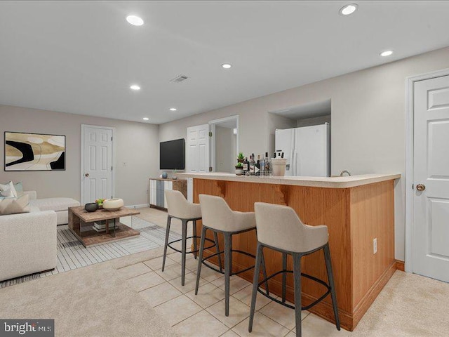 900 Young Dairy Ct, Herndon, VA 20170 - kitchen featuring freestanding refrigerator, a breakfast bar, recessed lighting, a peninsula, and light countertops
