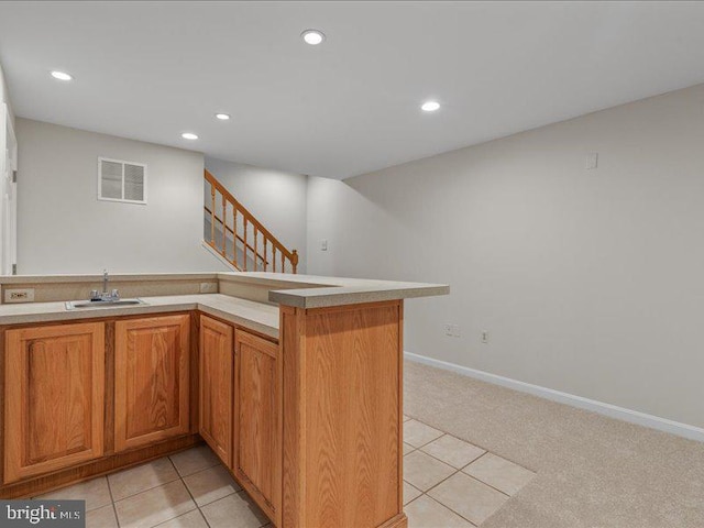 900 Young Dairy Ct, Herndon, VA 20170 - kitchen with recessed lighting, light tile patterned floors, light countertops, brown cabinetry, and light carpet