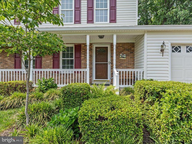 900 Young Dairy Ct, Herndon, VA 20170 - entrance to property featuring brick siding, a garage, and covered porch