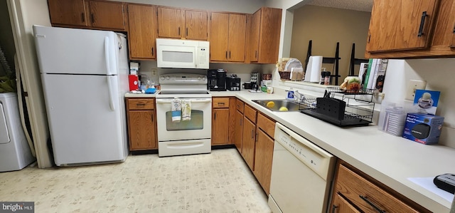 540 Berberis Plz, Monroe Township, NJ 08831 - kitchen featuring white appliances, brown cabinetry, light countertops, washer / clothes dryer, and a textured ceiling
