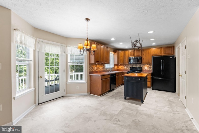 135 Hobbs Hole Ln, Tappahannock, VA 22560 - kitchen featuring black appliances, a chandelier, decorative backsplash, brown cabinetry, and a textured ceiling
