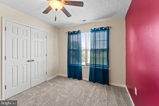 135 Hobbs Hole Ln, Tappahannock, VA 22560 - unfurnished bedroom with a textured ceiling, carpet flooring, a closet, and ceiling fan